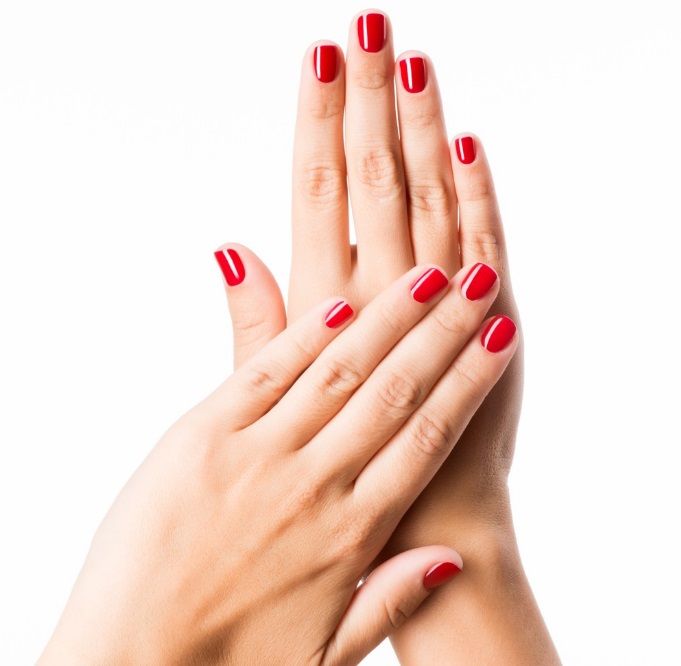 Des mains avec du vernis rouge