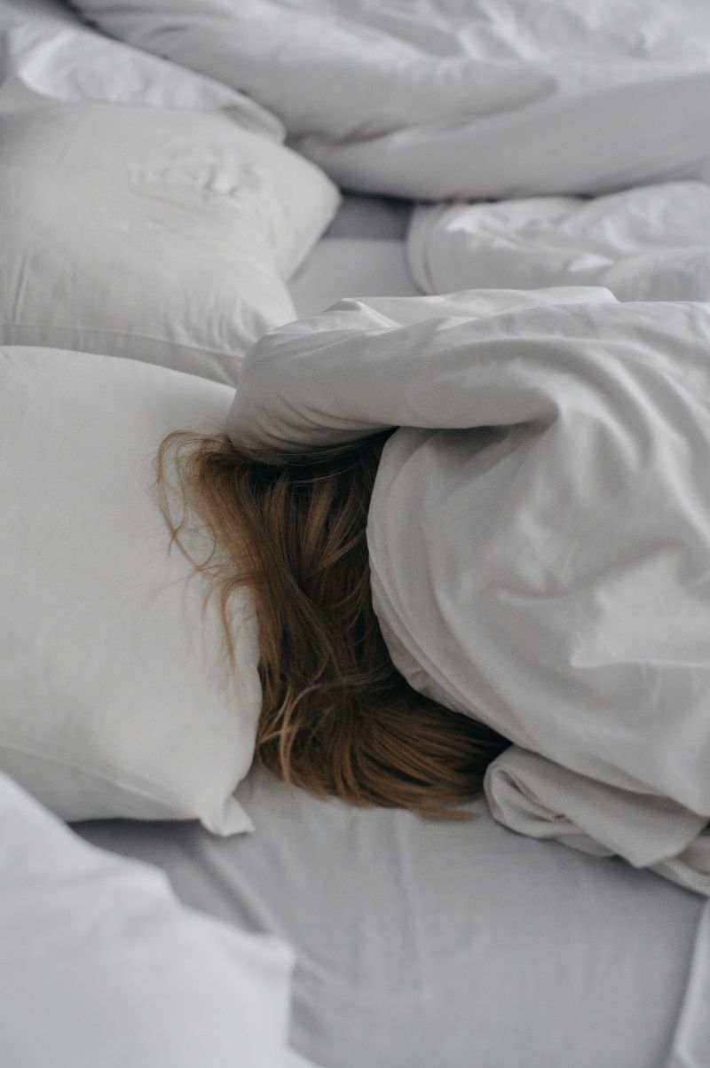 femme-cachee-sous-la-couette-dans-le-lit
