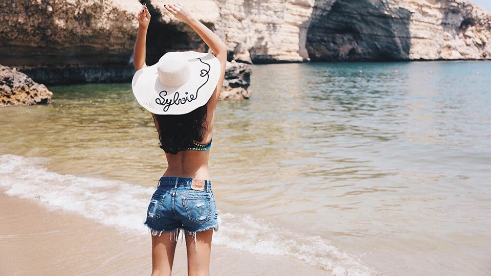 femme-en-maillot-de-bain-et-short-a-la-plage