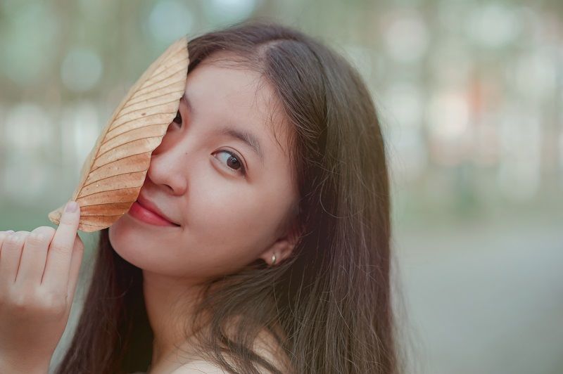 femme-qui-se-cache-derriere-une-feuille