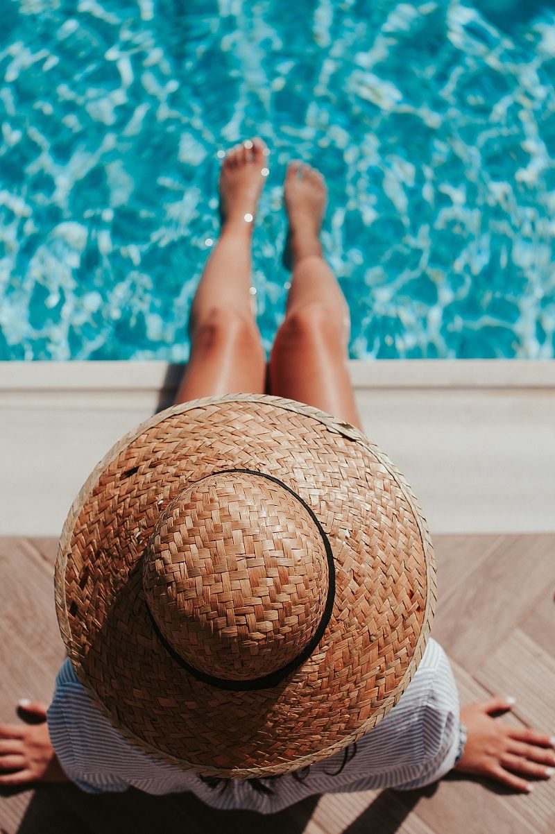 femme-trempe-ses-jambes-dans-la-piscine