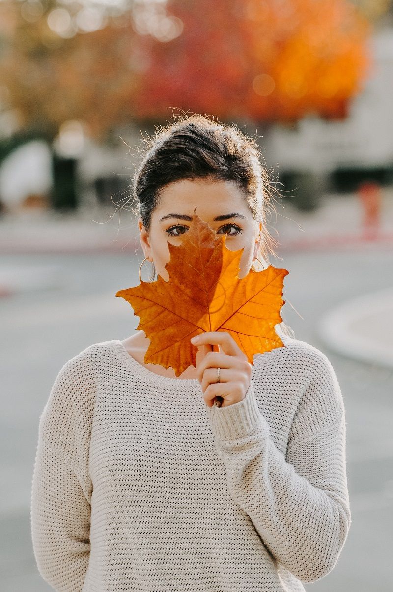 femme-visage-cache-derriere-une-feuille-morte-automne